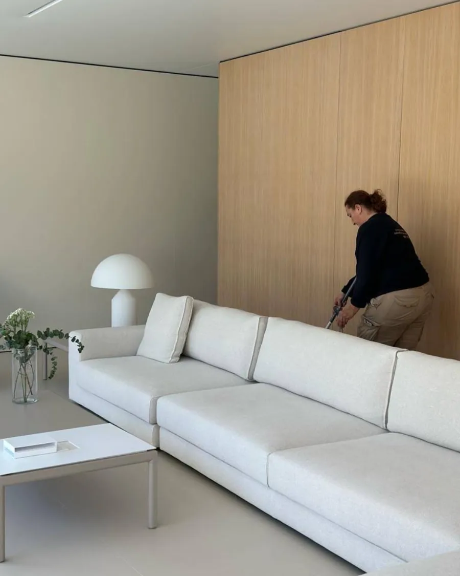 Trabajadora de Limpiezas Artemisa aspirando el salón de una vivienda