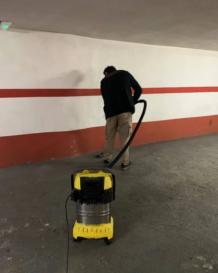 Trabajador de Limpiezas Artemisa aspirando el suelo de un garaje comunitario